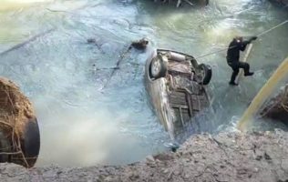 Intentan rescatar a tripulantes de auto que cayó a canal en Izcalli